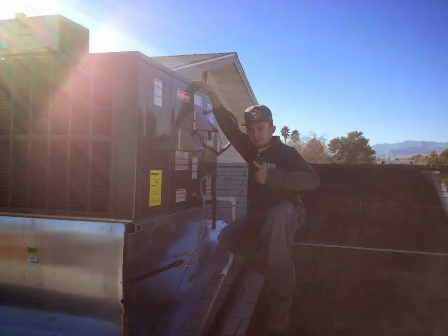 HVAC technician performing Boiler Repair on a rooftop unit in Scaggsville