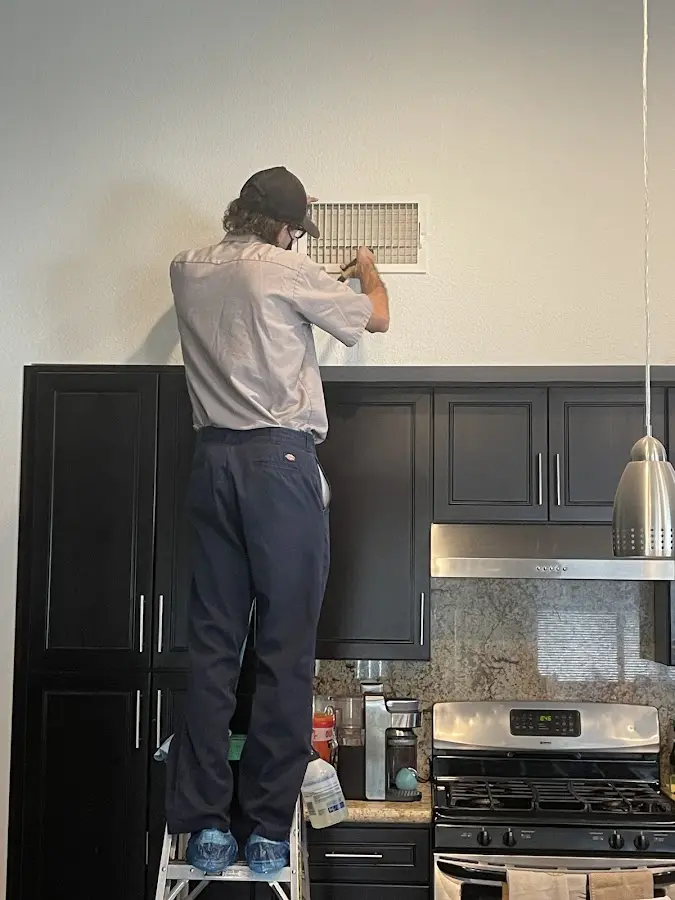 Technician inspecting an air vent during HVAC service in Scaggsville